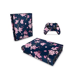 以下が含まれることがあります： ピンクの桜の花柄のダークブルーのXboxコンソールとコントローラーのスキ​​ン