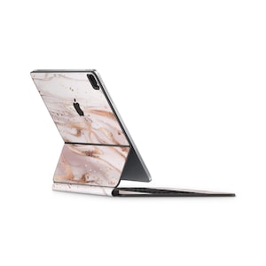 May include: A white and rose gold marble iPad case with a matching keyboard. The case has a subtle shimmer and a modern design.