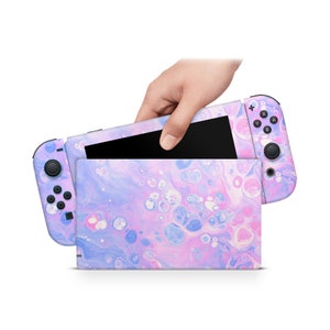 May include: A pink and blue abstract swirl design Nintendo Switch console skin. The skin is applied to the console and the two Joy-Con controllers.