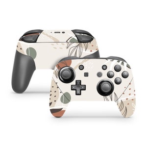 May include: A white Nintendo Switch controller with a beige, brown, and green abstract floral pattern. The controller has black buttons and joysticks.