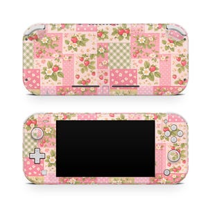 Pode incluir: Uma capa para consola de jogos com um design de patchwork rosa e branco. O padrão inclui morangos, flores e quadrados vichy. A capa cobre a consola e os comandos, criando uma estética coesa.