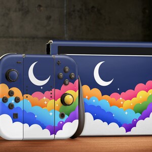 May include: A blue and white Nintendo Switch console and controller skin with a rainbow cloud and crescent moon design.