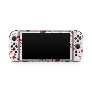 May include: White Nintendo Switch console with a blood splatter design. The console features a black screen and red and black buttons. The Joy-Con controllers and the main body are covered in red splatters.