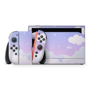 May include: A Nintendo Switch console and controllers with a custom skin featuring a pastel sky and cloud design. The controllers have black buttons and joysticks, with a coral-colored rail. The console's screen is visible in the background.