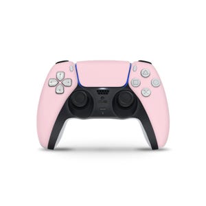 May include: A pink wireless game controller with black accents. The controller features a central touchpad, two analog sticks, and various buttons, including a directional pad and action buttons. The design is modern and sleek, with a focus on ergonomics.