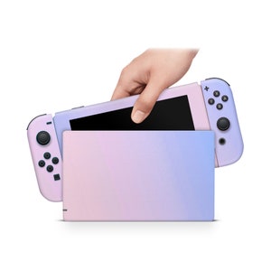 May include: A pink and purple ombre Nintendo Switch console with a black Joy-Con controller. The console is closed and the Joy-Con is attached to the console.