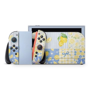 May include: A Nintendo Switch console with a lemon-themed design. The Joy-Con controllers and console feature a pattern of lemons, blue bows, and floral elements on a white and blue background. The screen frame is light blue.