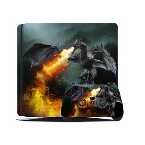 May include: A gaming console and controller set with a fantasy dragon design. The console has a dark green and black background with a dragon breathing fire. The controller has a matching dragon design with orange and green accents.