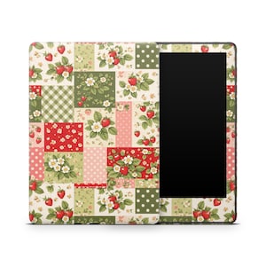 May include: A tablet case with a patchwork design featuring strawberries, flowers, and green leaves on a cream background. The case has a black screen area on the right side. The patchwork includes red, pink, and green squares.