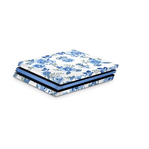 May include: A white gaming console with a blue and white floral pattern skin. The console is closed and has a blue and black trim.