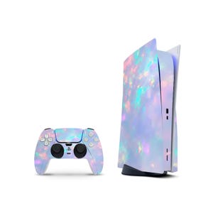 May include: A gaming console and a wireless controller featuring a custom skin with an iridescent, light-reflecting pattern of soft pastel pink, blue, and purple bokeh light spots against a pale, ethereal, and cloudy lavender background.