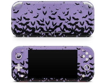 Op de afbeelding: Een paarse handheld gameconsole met een zwart vleermuismotief. De console heeft een zwart scherm en knoppen. Het vleermuismotief bedekt de hele console en creëert een spookachtige esthetiek.