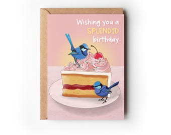 Peut inclure: Une carte d'anniversaire rose avec une part de gâteau surmontée d'un glaçage rose et d'une cerise. Deux oiseaux bleus sont perchés sur le gâteau. La carte dit "Wishing you a SPLENDID birthday."