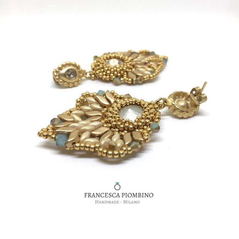 Hand-sewn gold earrings with beads and crystals.