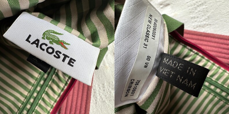 May include: Close-up of a white tag with the Lacoste logo, a green crocodile with red accents, and the brand name in black. The tag is sewn into striped fabric in green and white, with a pink fabric visible.