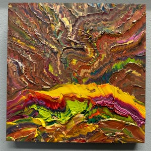 Puede incluir: Pintura abstracta cuadrada con pinceladas gruesas y texturizadas. La obra presenta una paleta de colores vibrantes, incluyendo marr&oacute;n, amarillo, verde, rojo y morado. La composici&oacute;n evoca un paisaje o una formaci&oacute;n geol&oacute;gica.