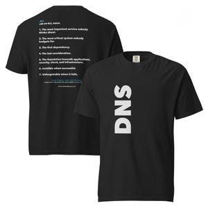 May include: A black t-shirt featuring the word DNS printed vertically in large white letters on the front. The back displays a dictionary-style definition of DNS with seven numbered points, including the text The most important service.