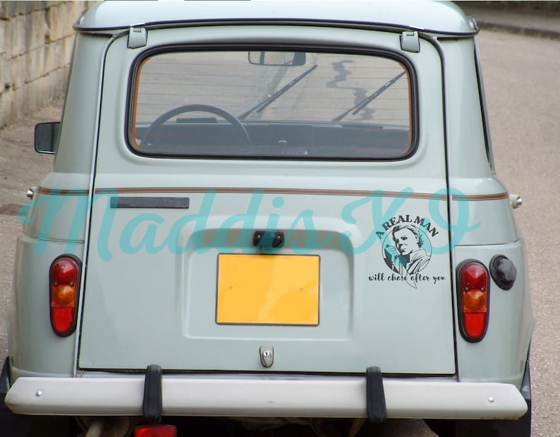 May include: A light blue car with a sticker on the back that says "A Real Man will chase after you" with a picture of a man in a black and white image.