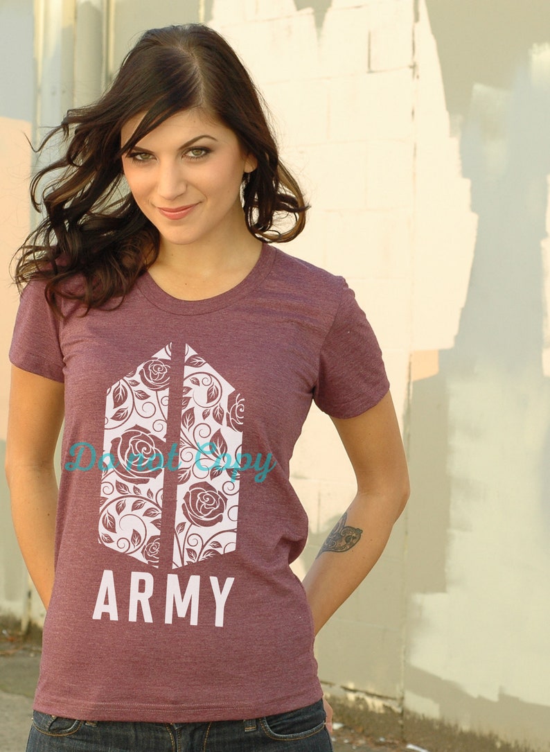Op de afbeelding: Een maroon t-shirt met een wit bloemmotief en de tekst "ARMY".