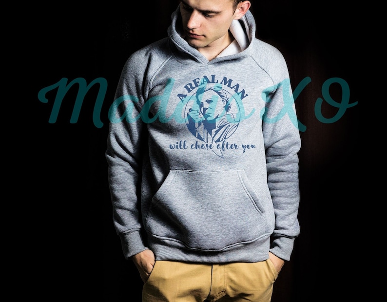 May include: A gray hooded sweatshirt with a graphic print of a man with a knife and the text "A Real Man Will Chase After You".