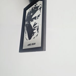 May include: Black and white framed photo of James Dean. The photo is a silhouette of James Dean's face.