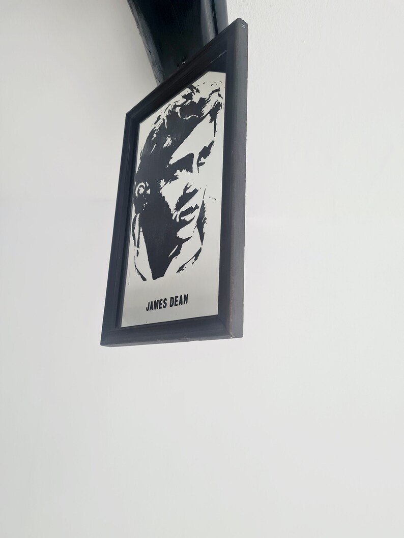 May include: Black and white framed photo of James Dean. The photo is a silhouette of James Dean's face.