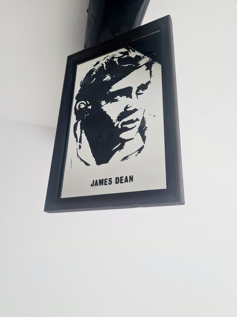 May include: Black and white silhouette portrait of James Dean in a black frame.