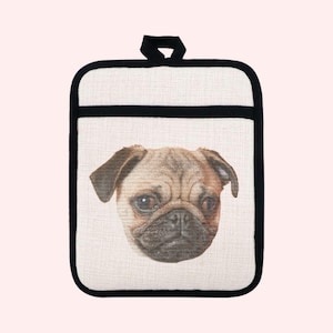 May include: A beige and black pot holder featuring a close-up of a pug's face. The pug has brown fur, dark eyes, and a wrinkled face. The pot holder has a black border and a loop for hanging.