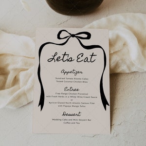 Puede incluir: Una tarjeta de menú con la frase "Let's Eat" en escritura cursiva, enmarcada por un diseño de cinta negra. El menú enumera aperitivos, platos principales y postres, incluyendo platos como Risotto de tomate seco y Salmón glaseado con albaricoque.