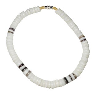 May include: White beaded necklace with alternating sections of white and dark gray beads. The necklace has a clasp closure and is made of small, round beads. The necklace is a simple, elegant piece of jewelry.