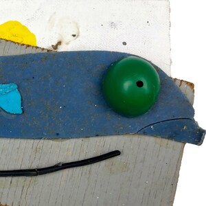 May include: A mixed media artwork featuring a blue, green, and white abstract design on a gray background. The artwork is made with various materials, including wood, plastic, and paint.