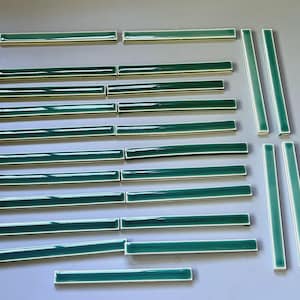 Peut inclure: Un ensemble de carreaux de céramique rectangulaires avec une finition vert émeraude brillante et des bords clairs. Les carreaux sont disposés en rangées horizontales et colonnes verticales, présentant une surface lisse et réfléchissante.