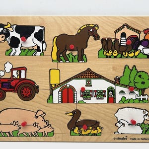 Può includere: Puzzle in legno a tema fattoria con mucca, cavallo, pollaio, trattore, fattoria, maiale con maialini, anatra con anatroccoli e pecora. Pezzi colorati per bambini. Prodotto in Olanda.