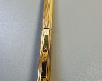 Bolígrafo vintage Must de Cartier Trinity Godron chapado en oro con cabujón, serializado.