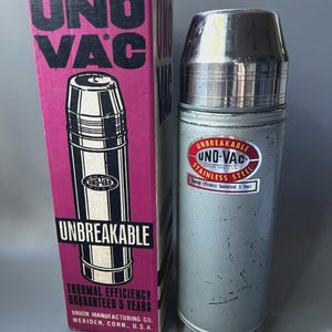 以下が含まれることがあります： クロームキャップと赤白のラベルが付いたグレーのステンレス製Uno-Vac魔法瓶。Uno-Vac、Unbreakable、Union Manufacturing Co.という文字が印刷された、背の高い長方形のピンクと白の段ボール箱が付属しています。