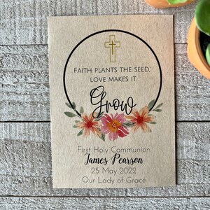 May include: A brown card with a gold cross and floral wreath. The text reads "Faith plants the seed, love makes it grow. First Holy Communion James Pearson 25 May 2022 Our Lady of Grace."