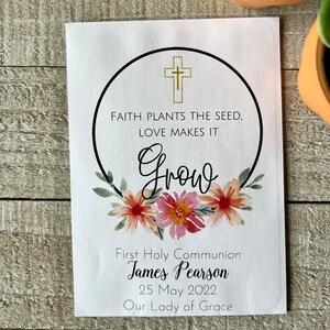 May include: White card with a black circle and gold cross. The text inside the circle reads "Faith plants the seed, love makes it grow". Below the circle are the words "First Holy Communion James Pearson 25 May 2022 Our Lady of Grace".