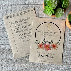 May include: A brown paper card with a floral wreath and a cross. The text reads "Faith plants the seed, love makes it grow". Below the wreath is the text "First Holy Communion James Pearson 25 May 2022 Our Lady of Grace".