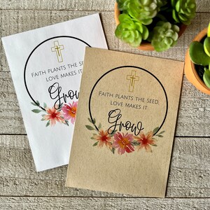 May include: Two seed packets with a floral design and the text "Faith plants the seed. Love makes it grow."  The packets are on a wooden surface.