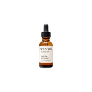 Op de afbeelding: Een bruine glazen fles met een zwarte druppelaar, met het label "FACE SERUM". De fles bevat een serum voor alle huidtypen dat gemakkelijk wordt opgenomen, anti-aging is, acne bestrijdt, de huidtint egaliseert en rijk is aan antioxidanten.