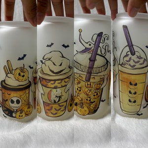 May include: Four frosted glass tumblers with Halloween-themed designs. Each tumbler features a different character from The Nightmare Before Christmas, including Jack Skellington, Sally, and Oogie Boogie. The designs are printed in orange, black, and purple.