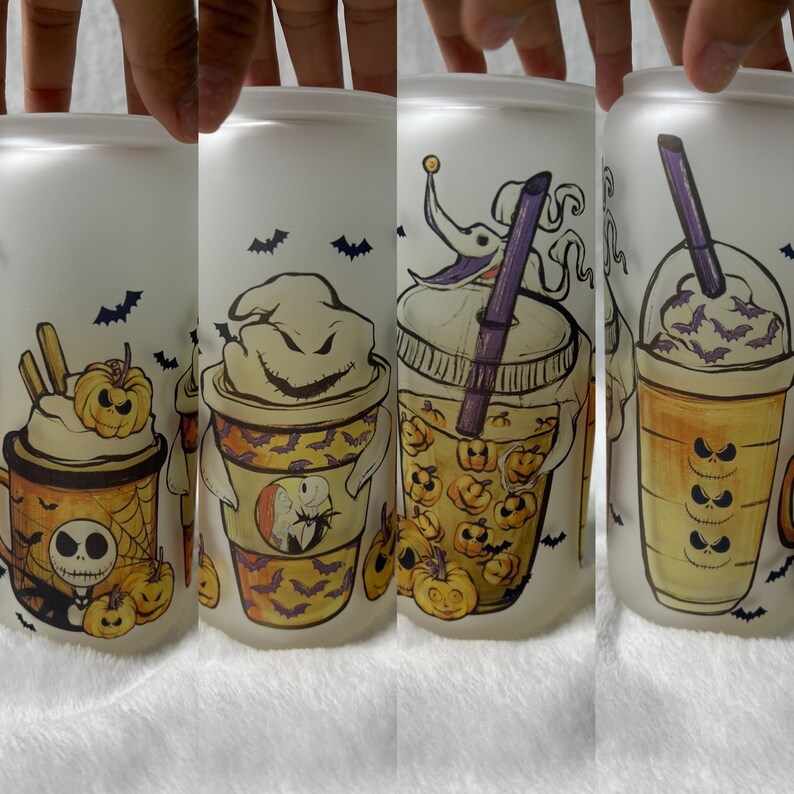 May include: Four frosted glass tumblers with Halloween-themed designs. Each tumbler features a different character from The Nightmare Before Christmas, including Jack Skellington, Sally, and Oogie Boogie. The designs are printed in orange, black, and purple.