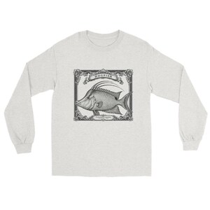 Puede incluir: Una camiseta de manga larga de color gris claro con una ilustración vintage en blanco y negro de un pez hogfish centrada en el pecho. El pez está dentro de un marco rectangular ornamentado con el texto HOGFISH y Lachnolaimus maximus.