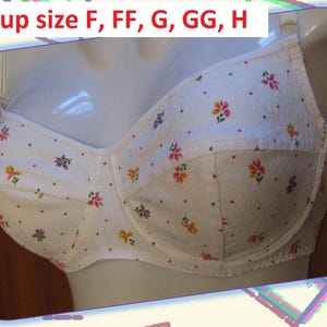 May include: White bra with a floral pattern in pink, yellow, and purple. The bra is displayed on a mannequin. Text at the top reads "Bra cup size F, FF, G, GG, H".