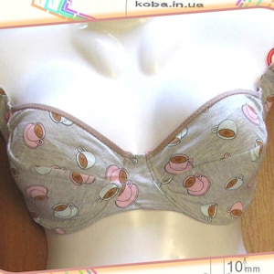 May include: A gray bra with a coffee cup print. The bra has adjustable straps and a hook and eye closure in the back.