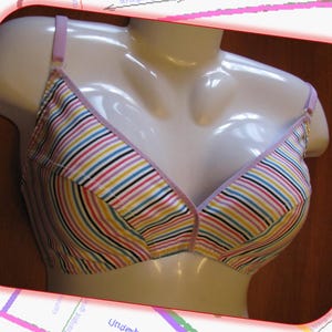 Puede incluir: Un sujetador a rayas con un ribete lavanda. El sujetador está hecho de una tela suave y elástica y tiene un ajuste cómodo.