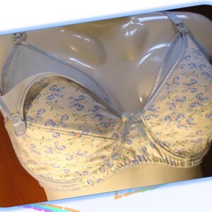 May include: A white and blue floral print nursing bra with a light blue fabric panel on the cups.