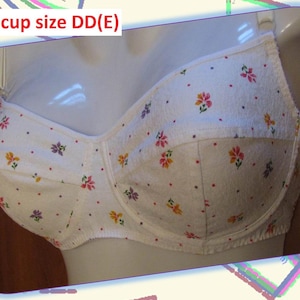 May include: White bra with a floral pattern in pink, yellow, and purple. The bra is displayed on a mannequin. The text "Bra cup size DD(E)" is visible at the top of the image.