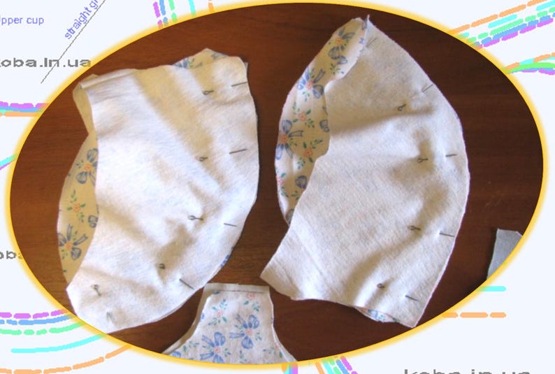 May include: Two pieces of white fabric with floral patterned fabric on the back are pinned together. The fabric is pinned along the curved edge.