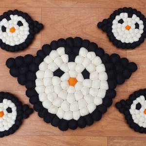 Puede incluir: Conjunto de cinco posavasos de fieltro con forma de pingüino. Los posavasos son negros y blancos, de forma redonda y con un diseño de cara de pingüino. Los posavasos son perfectos para proteger tus muebles de las bebidas calientes.